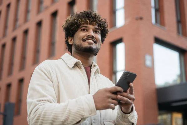 Lächelnder Indischer Mann Der Online Mit Dem Handy Einkauft Und Stockfoto