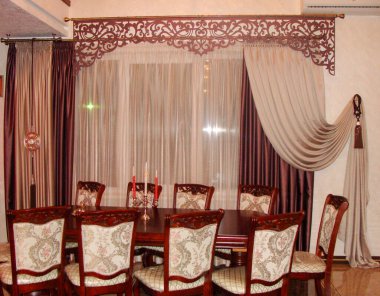                      , ,                                   Oturma odasının içinde perdeler, masa, tül ve açılış lambrequin 'i var.            