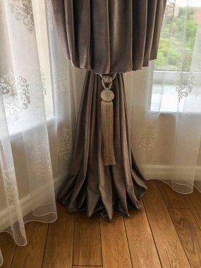 Perdenin bir kısmı odanın iç kısımlarına sarılı.