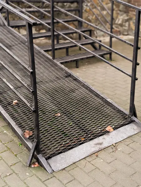 Dükkânın yanındaki metal rampada.