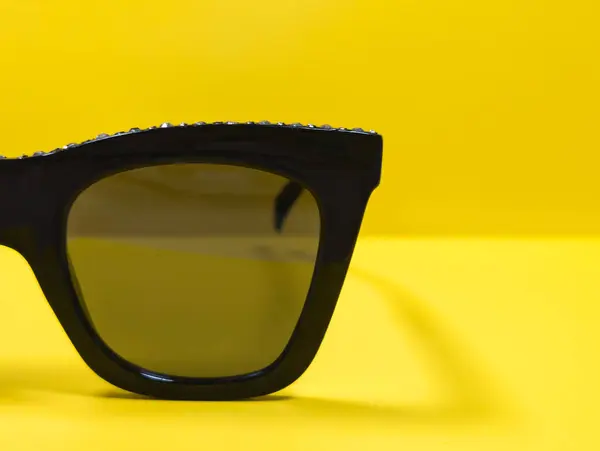 sarı arkaplanda siyah güneş gözlüğü