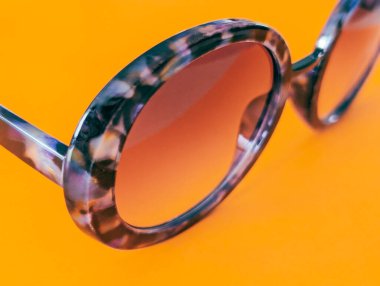 turuncu arka planda yuvarlak mor güneş gözlüğü