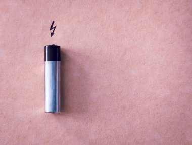 enerji simgesiyle kahverengi pastel arkaplanda pil