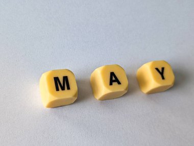 Sarı harf küpleri tarafından oluşturulan kelime MAY