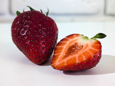 Açık beyaz taşlı arka planda yarım çilek.