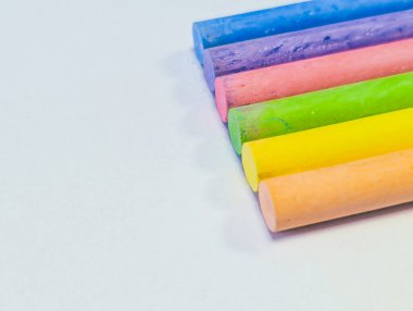 Parlak bir arkaplanda altı renkli tebeşir çubuğu