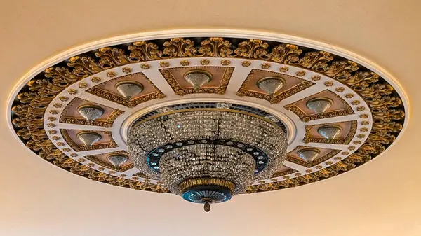 Lüks tiyatro tavanında büyük bir kristal avize ve karmaşık dekoratif alçı var.