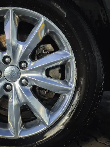 Gümüş alaşımlı jantları ve tüm sezon boyunca 18 inç lastikleri olan bir Jeep off-road aracının dikey yakın çekimi