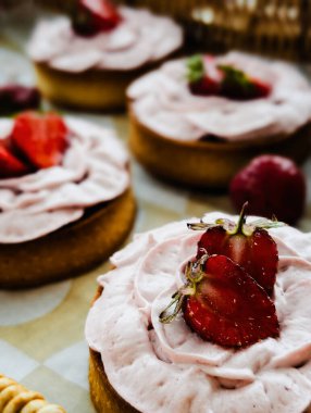 Üstünde taze çilek dilimleri olan çilekli turtalar.
