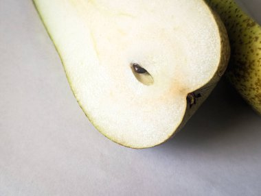 Hafif arkaplanda sulu yeşil bir armut.