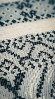 Etnik siyah nakış desenli geleneksel kumaşın dikey yakın çekimi, tekstil dokusu