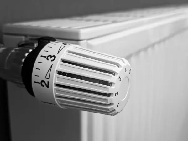 White radiator with thermostat, vertical, cozy home heating