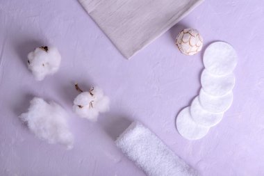 Clean towels, cotton pads  and  cotton flowers on table. Natural cotton fabric texture, top view