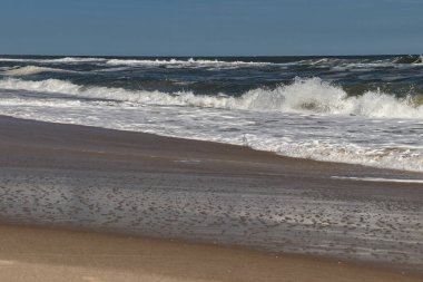 Öğleden sonra güneşiyle gelen dalganın sıçraması - Assateague, MD, ABD