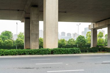 Şehirdeki üst geçidin altında beton yapı ve asfalt yol alanı