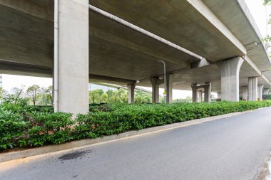 Şehirdeki üst geçidin altında beton yapı ve asfalt yol alanı