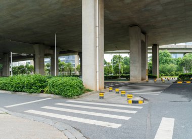 Şehirdeki üst geçidin altında beton yapı ve asfalt yol alanı