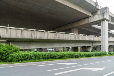 Şehirdeki üst geçidin altında beton yapı ve asfalt yol alanı