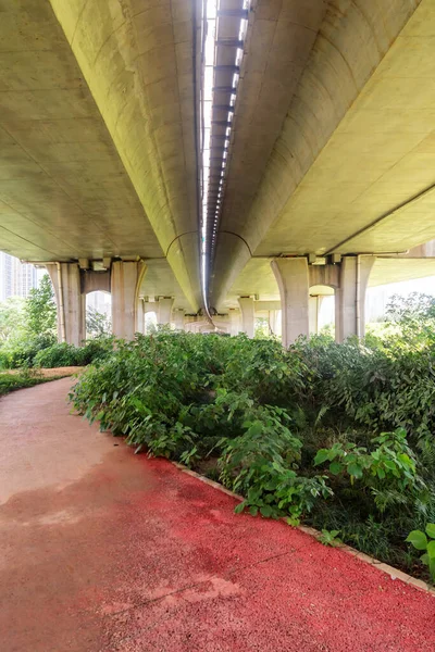 Şehirdeki üst geçidin altında beton yapı ve asfalt yol alanı