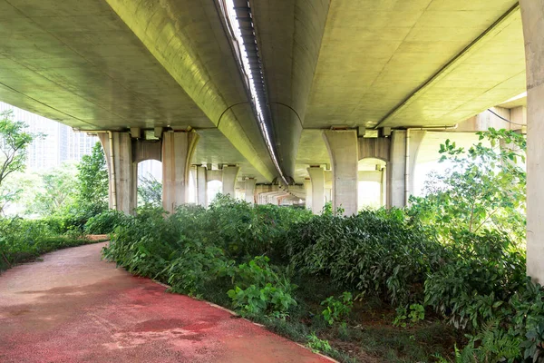 城市立交桥下的混凝土结构和沥青路面空间 免版税图库图片