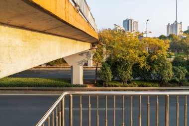 Şehirdeki üst geçidin altında beton yapı ve asfalt yol alanı