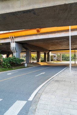 Şehirdeki üst geçidin altında beton yapı ve asfalt yol alanı