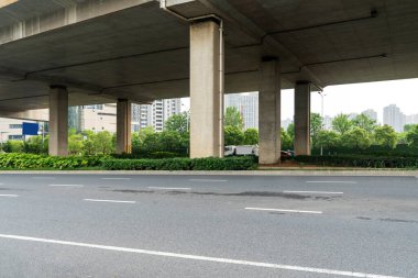 Şehirdeki üst geçidin altında beton yapı ve asfalt yol alanı