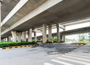 Şehirdeki üst geçidin altında beton yapı ve asfalt yol alanı