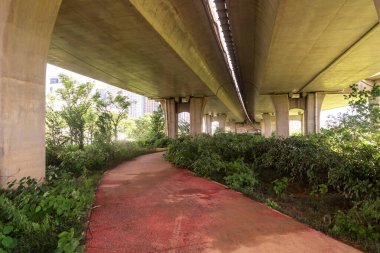 Şehirdeki üst geçidin altında beton yapı ve asfalt yol alanı