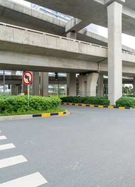 Şehirdeki üst geçidin altında beton yapı ve asfalt yol alanı