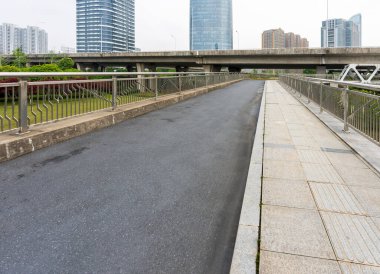 Şehirdeki üst geçidin altında beton yapı ve asfalt yol alanı