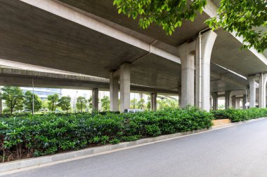 Şehirdeki üst geçidin altında beton yapı ve asfalt yol alanı