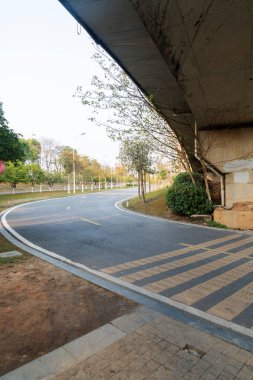 Şehirdeki üst geçidin altında beton yapı ve asfalt yol alanı