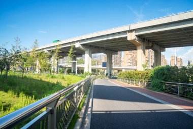 Şehirdeki üst geçidin altında beton yapı ve asfalt yol alanı