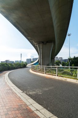 Şehirdeki üst geçidin altında beton yapı ve asfalt yol alanı