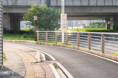 Şehirdeki üst geçidin altında beton yapı ve asfalt yol alanı