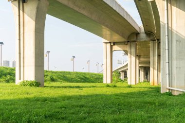 Şehirdeki üst geçidin altında beton yapı ve asfalt yol alanı