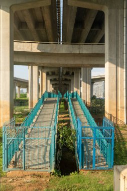 Şehirdeki üst geçidin altında beton yapı ve asfalt yol alanı