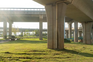 Şehirdeki üst geçidin altında beton yapı ve asfalt yol alanı