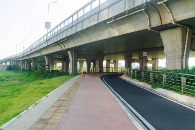 Şehirdeki üst geçidin altında beton yapı ve asfalt yol alanı