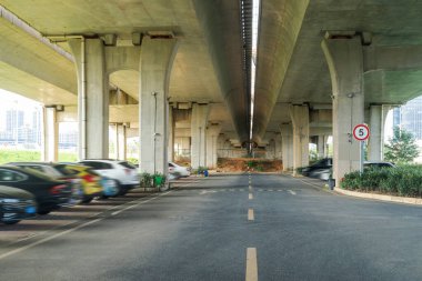 Şehirdeki üst geçidin altında beton yapı ve asfalt yol alanı