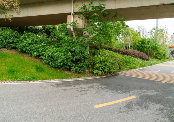 Şehirdeki üst geçidin altında beton yapı ve asfalt yol alanı