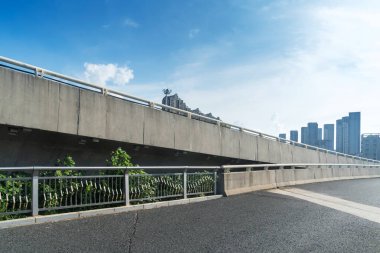 Şehirdeki üst geçidin altında beton yapı ve asfalt yol alanı