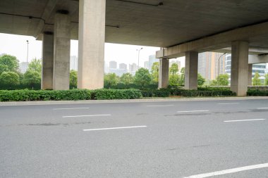 Şehirdeki üst geçidin altında beton yapı ve asfalt yol alanı