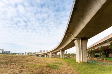Şehirdeki üst geçidin altında beton yapı ve asfalt yol alanı