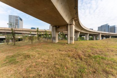 Şehirdeki üst geçidin altında beton yapı ve asfalt yol alanı