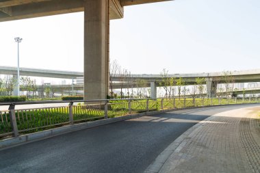 Şehirdeki üst geçidin altında beton yapı ve asfalt yol alanı