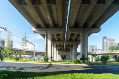 Şehirdeki üst geçidin altında beton yapı ve asfalt yol alanı