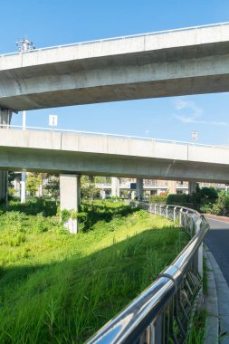 Şehirdeki üst geçidin altında beton yapı ve asfalt yol alanı
