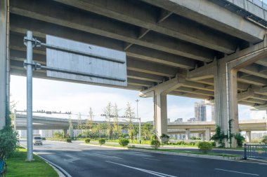 Şehirdeki üst geçidin altında beton yapı ve asfalt yol alanı